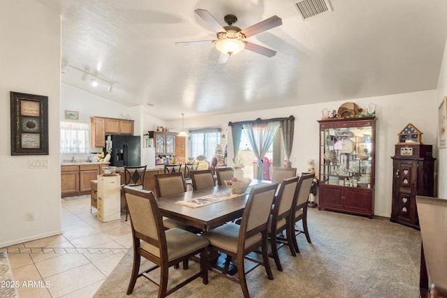dining area with visible vents, lofted ceiling, light tile patterned flooring, baseboards, and a ceiling fan