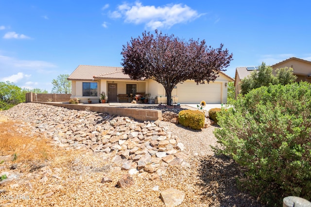 view of front of property with fence, stucco siding, an attached garage, and a tile roof