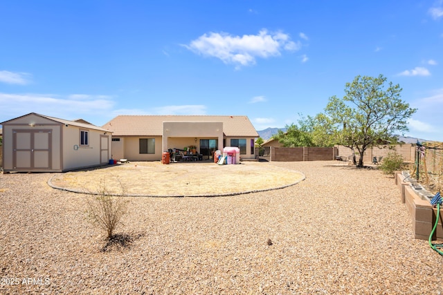 back of house featuring a storage unit, an outdoor structure, stucco siding, a patio, and a tiled roof