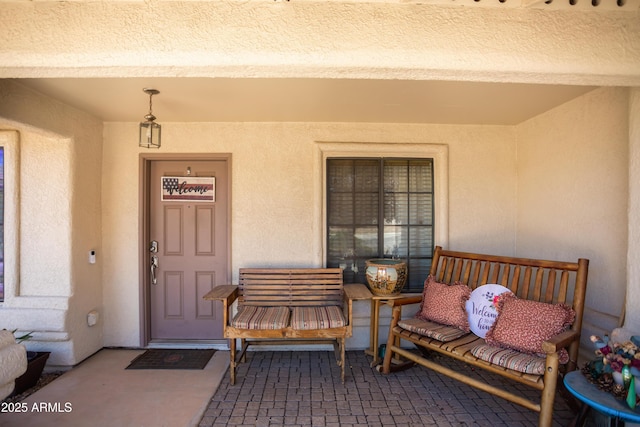 entrance to property with stucco siding and a porch