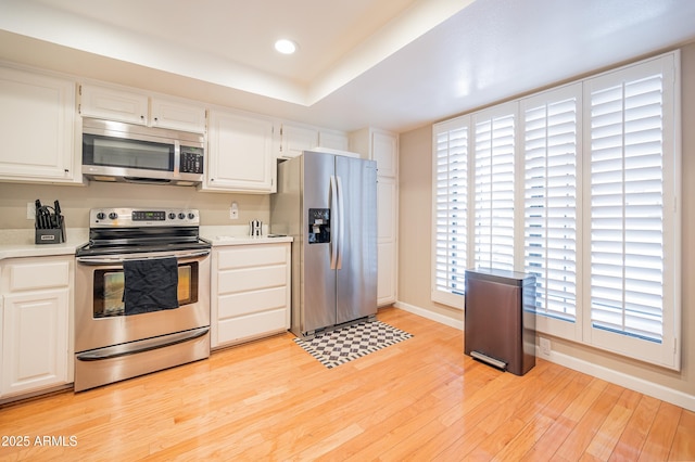 5102 N 31st Pl Unit 432, Phoenix, AZ 85016 - kitchen featuring appliances with stainless steel finishes, light countertops, light wood-style flooring, and baseboards