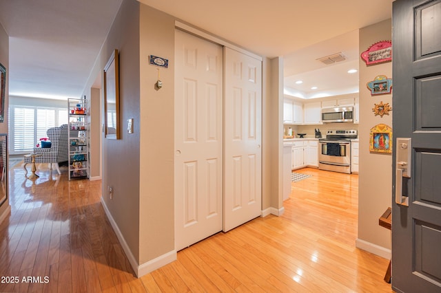 5102 N 31st Pl Unit 432, Phoenix, AZ 85016 - hall with baseboards, visible vents, light wood-style flooring, and recessed lighting