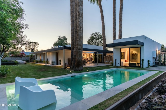 pool with a yard and a patio area