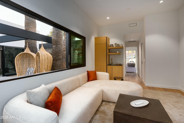 living area featuring recessed lighting, baseboards, and light wood-style flooring