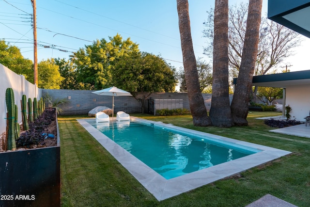 view of swimming pool featuring a fenced in pool, a fenced backyard, and a yard