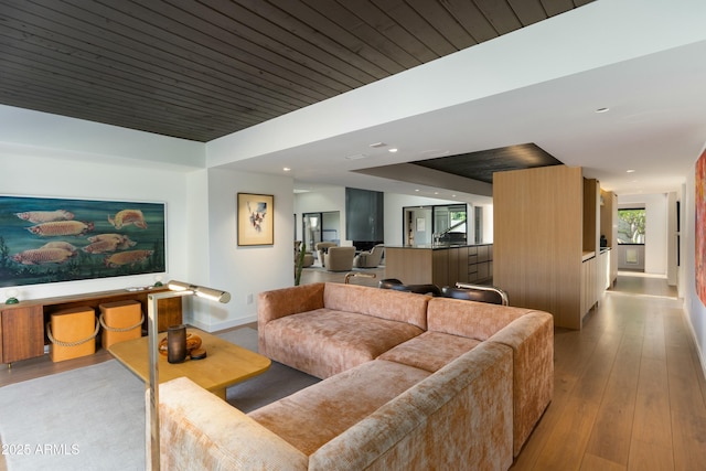 living room featuring baseboards, recessed lighting, and hardwood / wood-style floors
