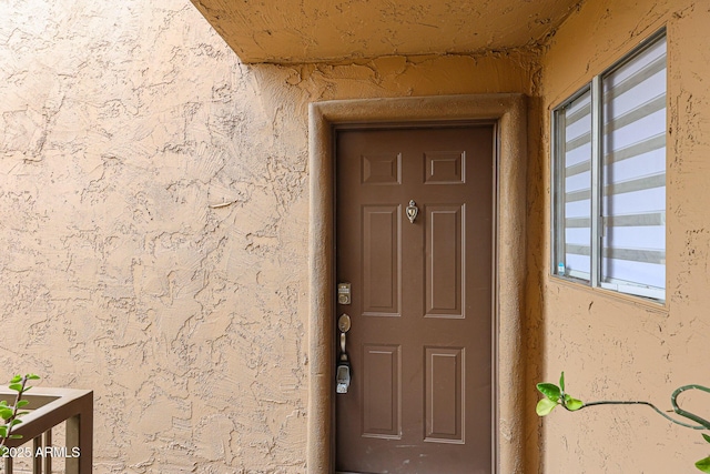 entrance to property featuring stucco siding