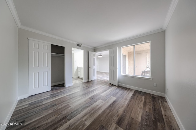 unfurnished bedroom featuring visible vents, baseboards, crown molding, and wood finished floors
