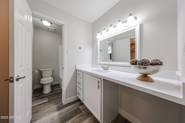 bathroom with vanity, visible vents, toilet, and wood finished floors