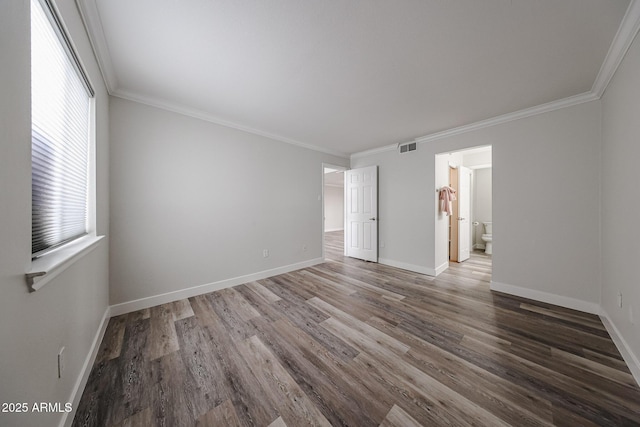 unfurnished room with visible vents, ornamental molding, baseboards, and wood finished floors