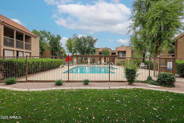 pool featuring a lawn and fence