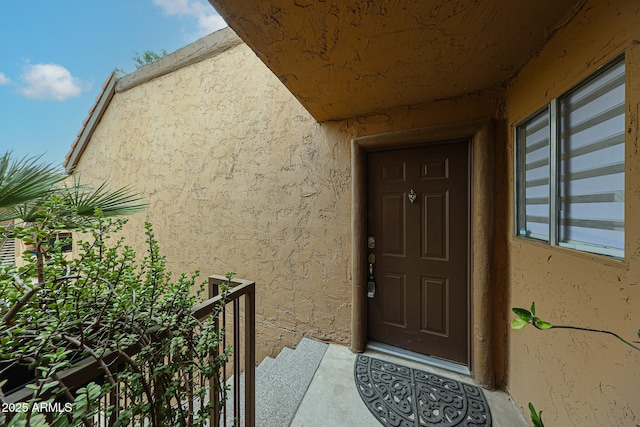 view of exterior entry featuring stucco siding