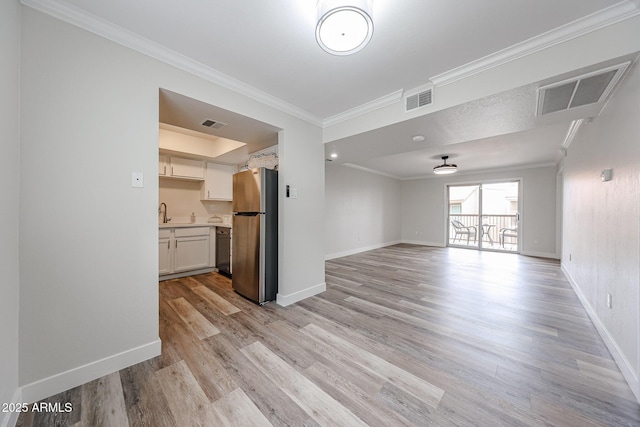 unfurnished living room with light wood-type flooring, baseboards, ornamental molding, and visible vents