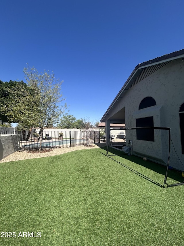 view of yard with a fenced in pool and fence