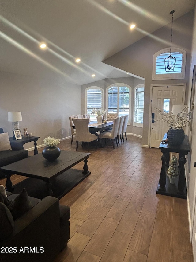 living area with recessed lighting, baseboards, high vaulted ceiling, and wood finished floors