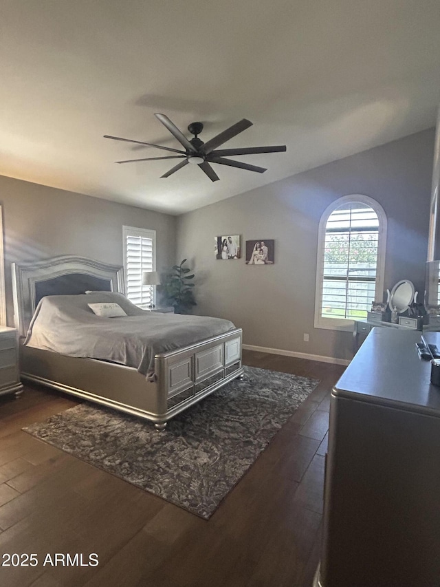 bedroom featuring dark wood finished floors, multiple windows, lofted ceiling, and ceiling fan