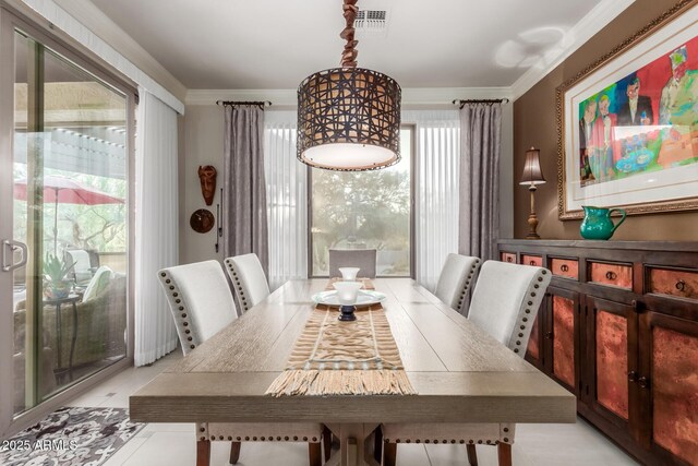 tiled dining space featuring crown molding