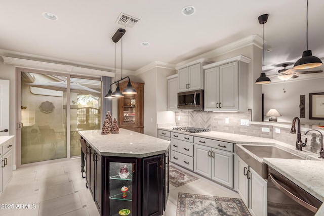 kitchen with backsplash, stainless steel appliances, ceiling fan, sink, and a center island