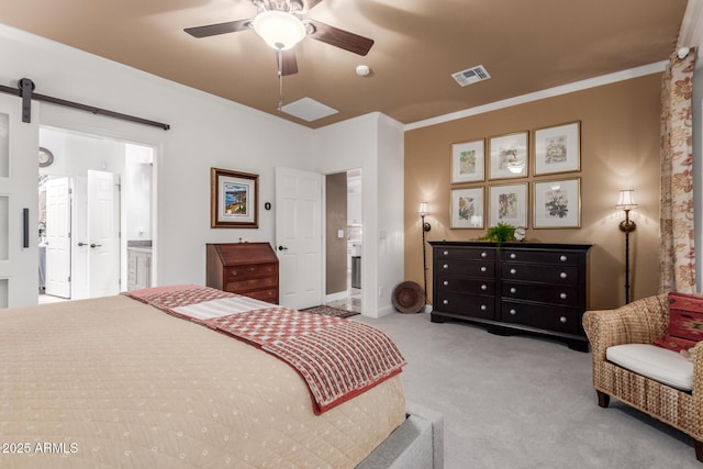 bedroom with ceiling fan, a barn door, ensuite bathroom, light carpet, and ornamental molding