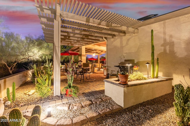 patio terrace at dusk featuring a pergola