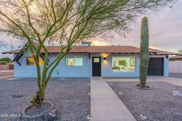 8547 E Roanoke Ave, Scottsdale, AZ 85257 - ranch-style home featuring an attached garage, a shingled roof, concrete driveway, and stucco siding