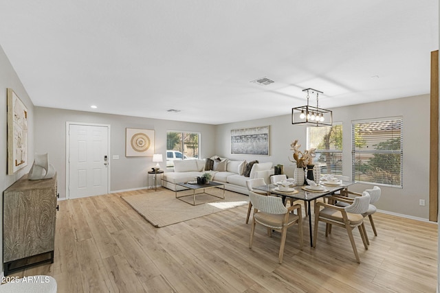 dining room with an inviting chandelier and light wood-type flooring