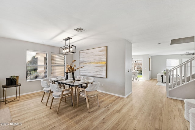 dining space with an inviting chandelier and light hardwood / wood-style flooring