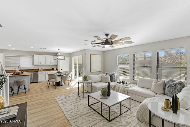 living room with light hardwood / wood-style flooring and ceiling fan