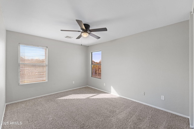 carpeted spare room featuring ceiling fan