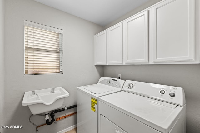 laundry area with sink, washer and clothes dryer, and cabinets