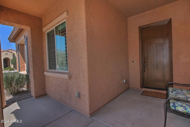 view of exterior entry with a patio area