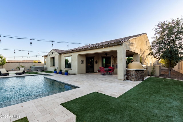 back of property featuring a lawn, ceiling fan, area for grilling, and a patio