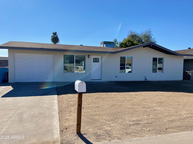 single story home featuring a garage, driveway, cooling unit, and stucco siding