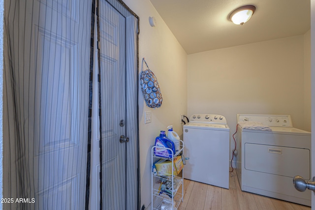 clothes washing area with light hardwood / wood-style flooring and independent washer and dryer