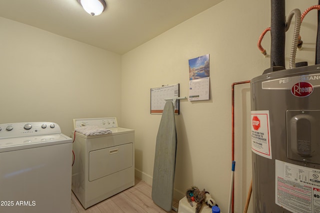 clothes washing area with washer and dryer, electric water heater, and light hardwood / wood-style floors