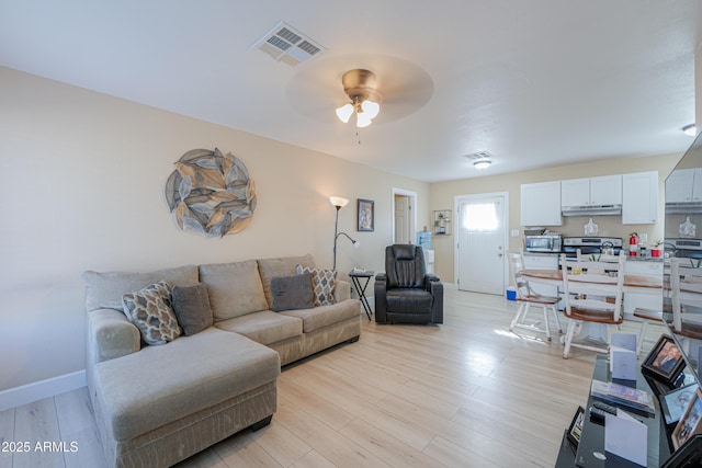 living area featuring a ceiling fan, visible vents, light wood-style flooring, and baseboards