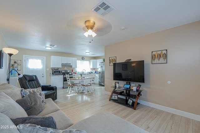 living room with ceiling fan and light hardwood / wood-style floors