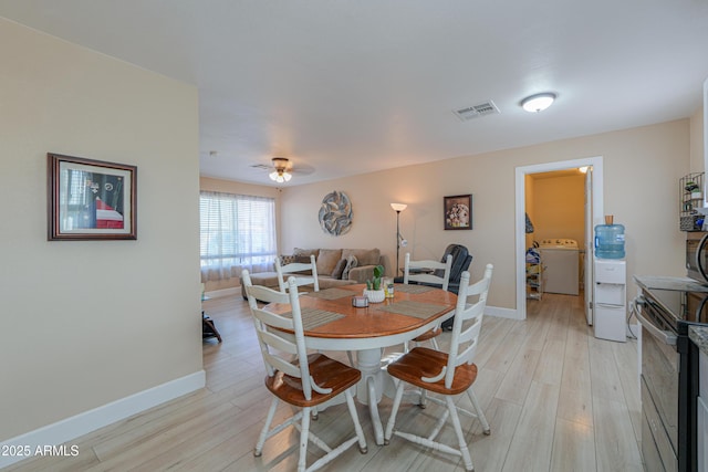 dining space with ceiling fan, light hardwood / wood-style floors, and washer / dryer