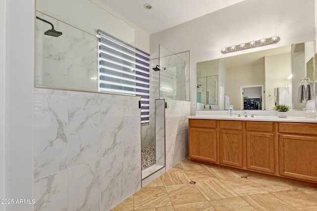 bathroom featuring a marble finish shower and vanity