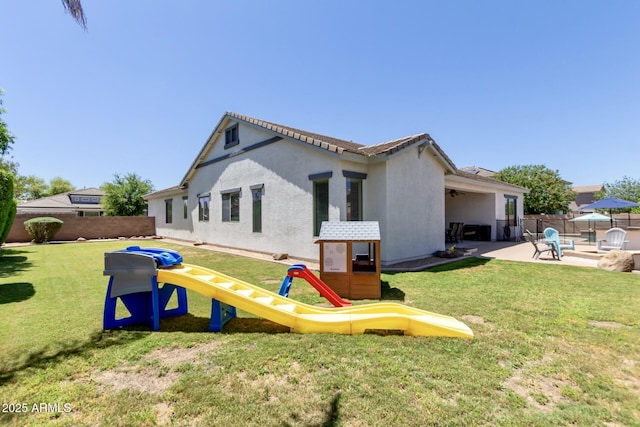 rear view of property featuring stucco siding and a patio area