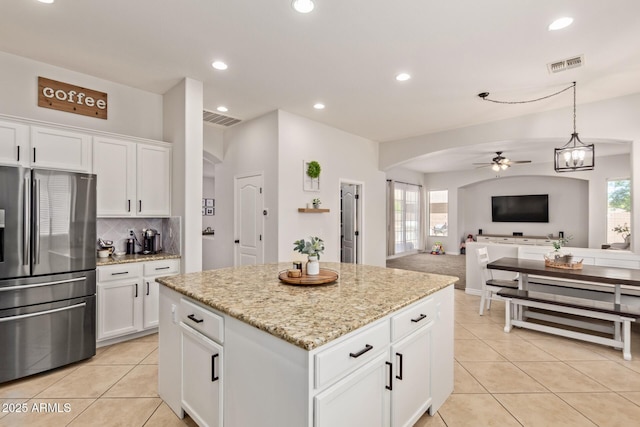 kitchen featuring stainless steel fridge with ice dispenser, a ceiling fan, arched walkways, light tile patterned floors, and recessed lighting