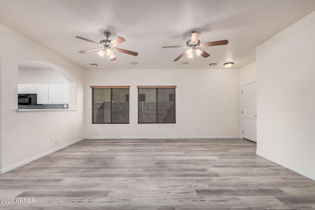 spare room featuring wood finished floors, visible vents, and baseboards