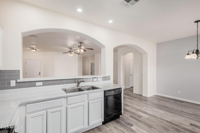 kitchen featuring visible vents, light wood finished floors, arched walkways, a sink, and dishwasher