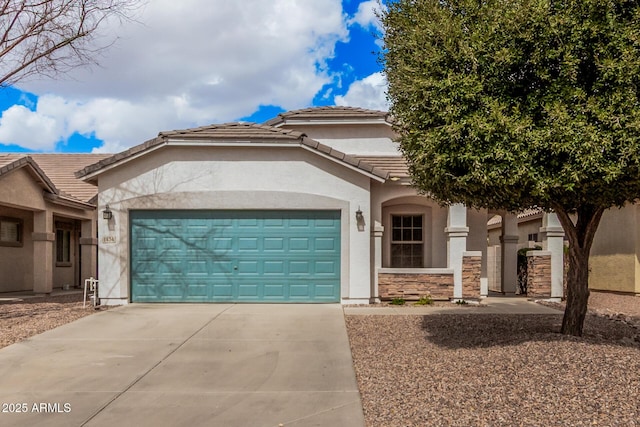 view of front of house featuring a tile roof, an attached garage, driveway, and stucco siding