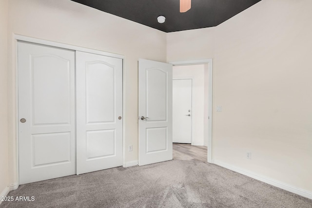 unfurnished bedroom with a closet, carpet flooring, and baseboards