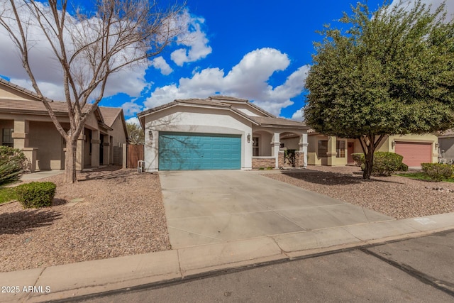 view of front facade with stucco siding, driveway, an attached garage, and a tile roof