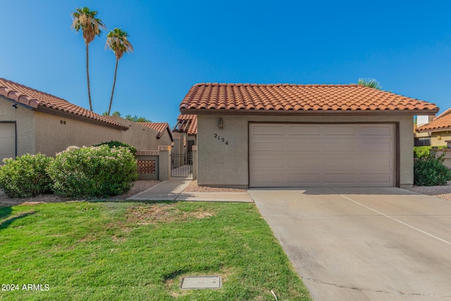 2154 E Forge Ave, Mesa, AZ 85204 - mediterranean / spanish-style house with a gate, driveway, stucco siding, a tiled roof, and a garage