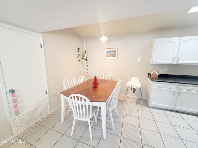 tiled dining room featuring a textured ceiling