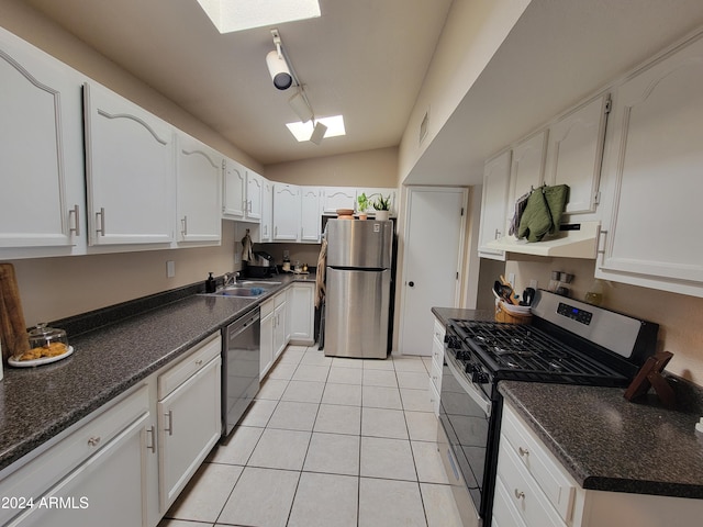 kitchen featuring lofted ceiling, premium range hood, light tile patterned floors, white cabinetry, and stainless steel appliances