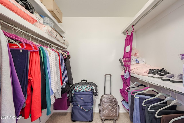 walk in closet featuring light colored carpet